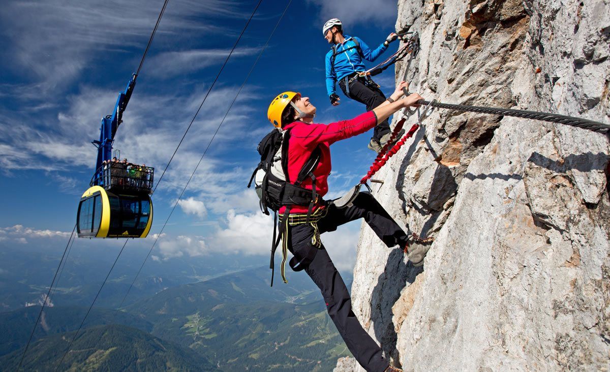 Kletterer im Klettersteig an der Dachstein Südwand - im Hintergrund die Gondel auf den Dachstein